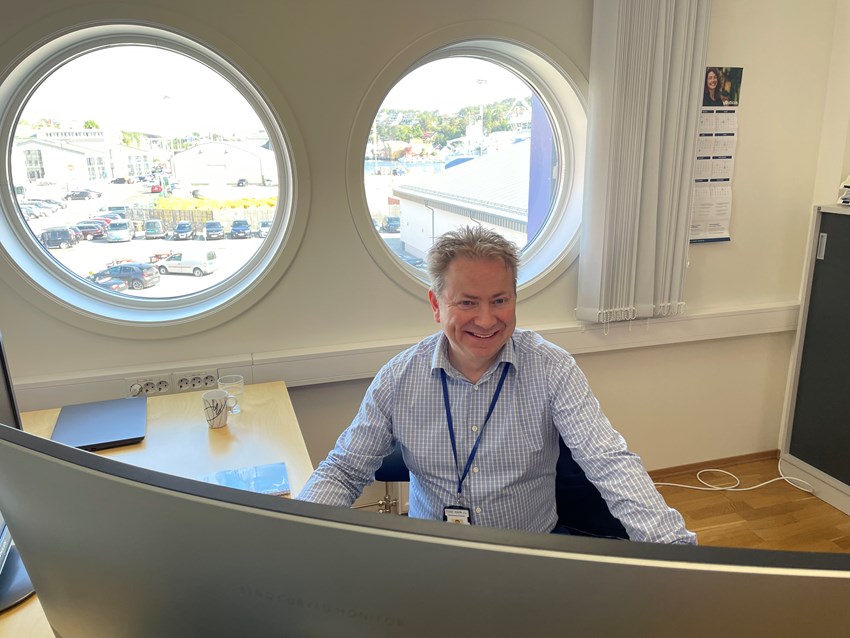 Tom Willy Kjønnø ved pulten på sitt kontor. Foto.