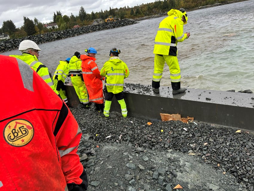 Folk i arbeidstøy som jobber med ny kaifront. Foto.